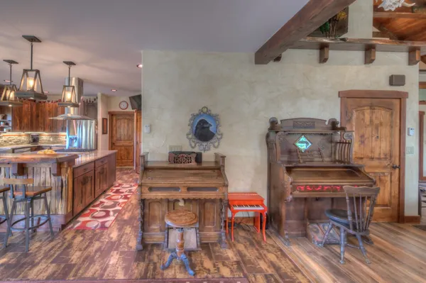 a open kitchen with stainless steel appliances kitchen island granite countertop a stove a refrigerator a dining table and chairs with wooden floor