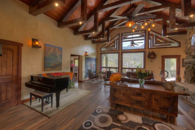 a living room with furniture a large window and wooden floor