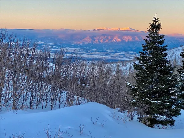 a view of mountain with sunset in background