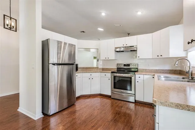 a kitchen with a refrigerator and a stove top oven