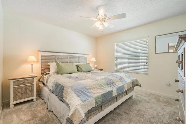a bedroom with a bed a chandelier and a chair