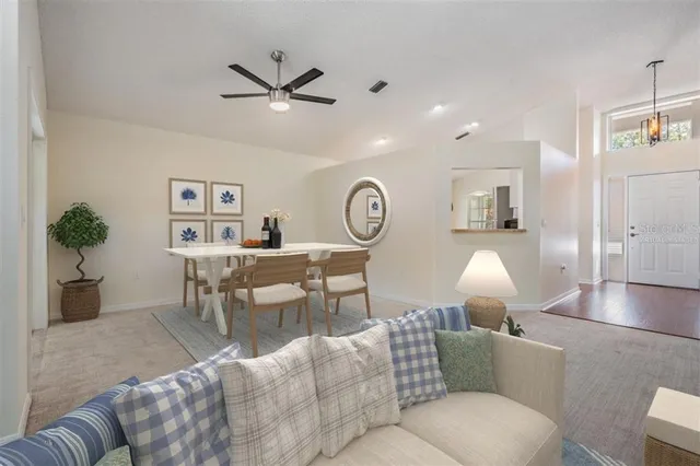 a living room with furniture a clock and a ceiling fan