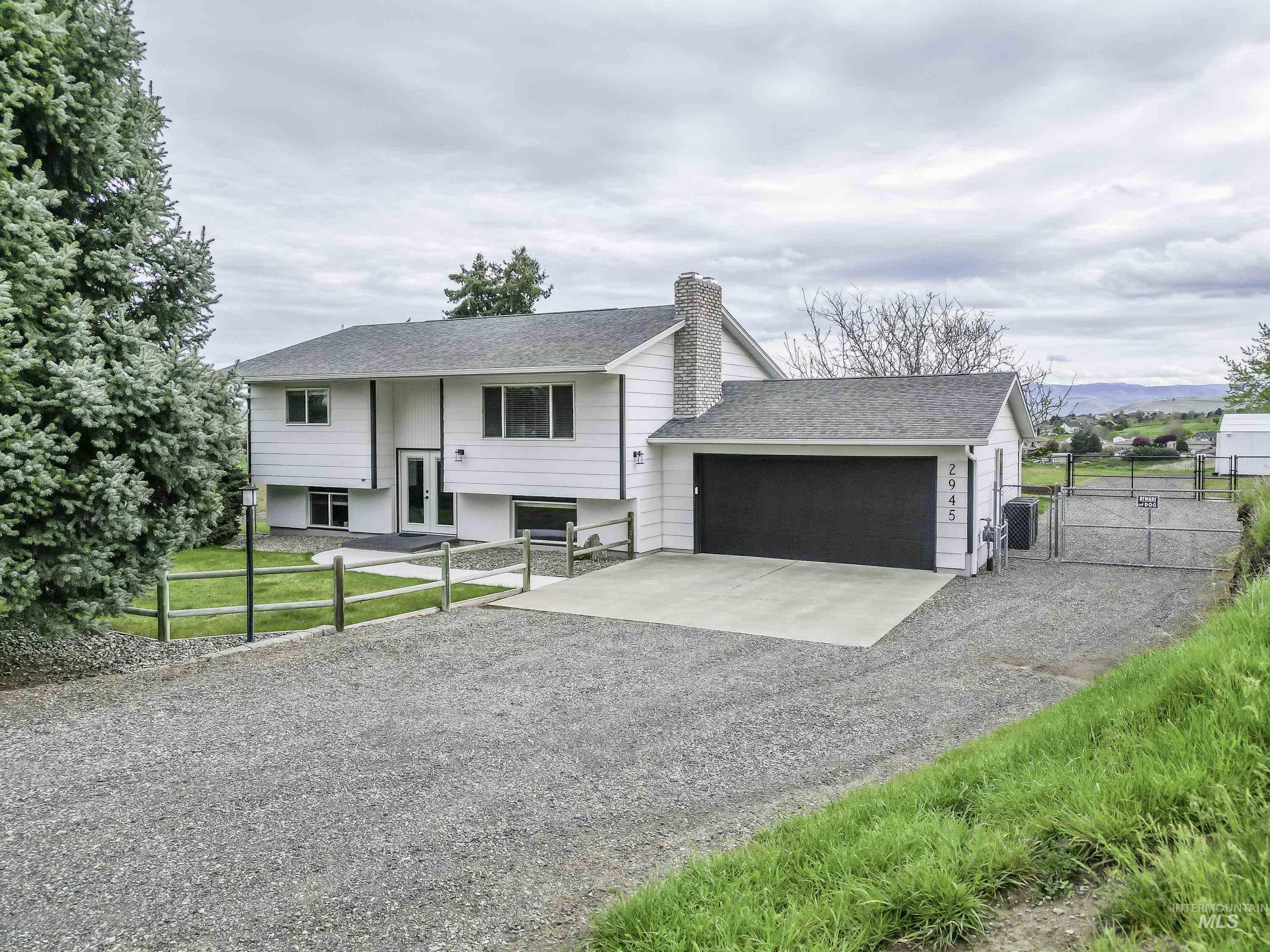 2945 25th Street Clarkston, WA 99403 - Photo 23 of 46 Split foyer home with a gate, gravel driveway, a chimney, roof with shingles, and a garage