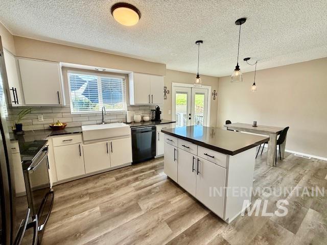 2945 25th Street Clarkston, WA 99403 - Photo 28 of 46 Kitchen featuring dark countertops, a kitchen island, light wood finished floors, and a textured ceiling