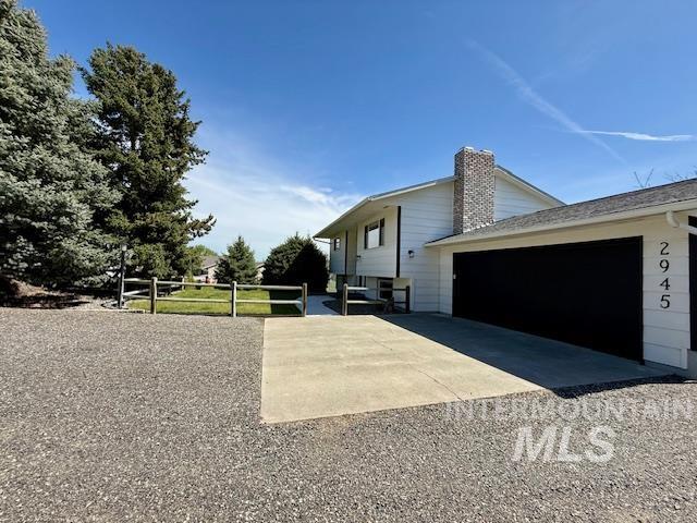 2945 25th Street Clarkston, WA 99403 - Photo 6 of 46 View of side of home with concrete driveway, a garage, and a chimney