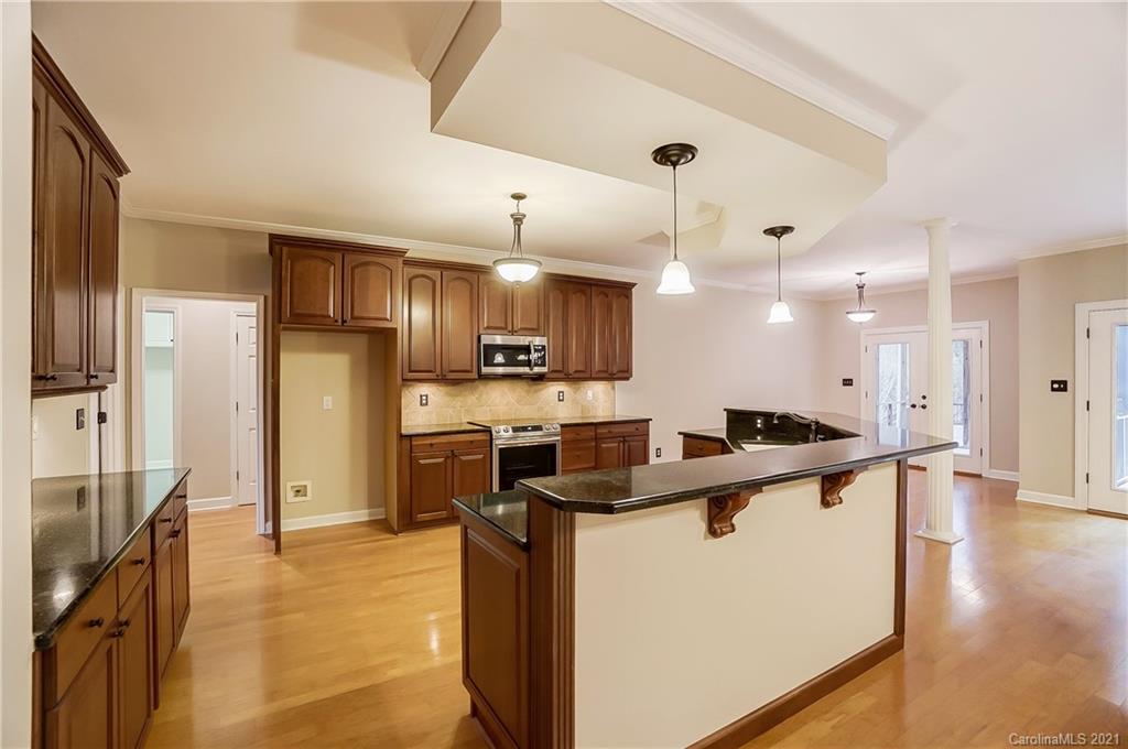 7064 Harbor Court Tega Cay, SC 29708 - Photo 12 of 48 a large kitchen with stainless steel appliances kitchen island granite countertop a refrigerator a stove a sink and a microwave