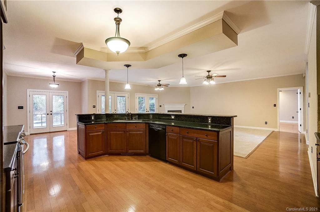 7064 Harbor Court Tega Cay, SC 29708 - Photo 13 of 48 a large kitchen with stainless steel appliances granite countertop a stove and a wooden floors