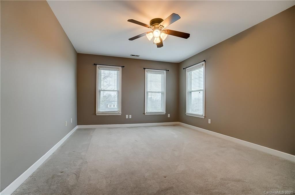 7064 Harbor Court Tega Cay, SC 29708 - Photo 38 of 48 an empty room with windows and ceiling fan
