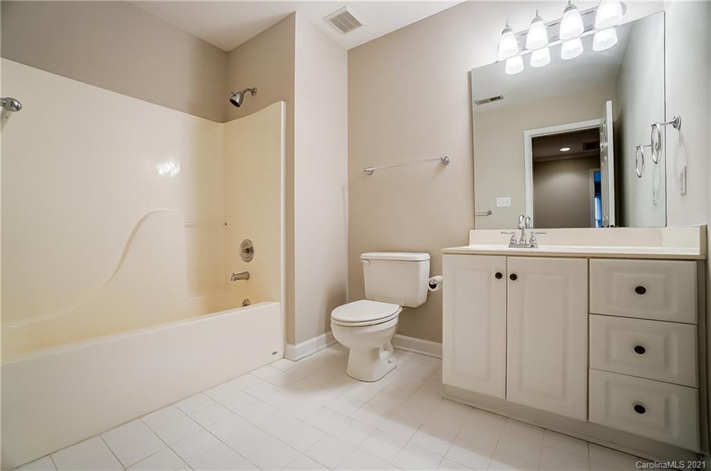7064 Harbor Court Tega Cay, SC 29708 - Photo 40 of 48 a bathroom with a toilet a sink a mirror a bathtub and shower