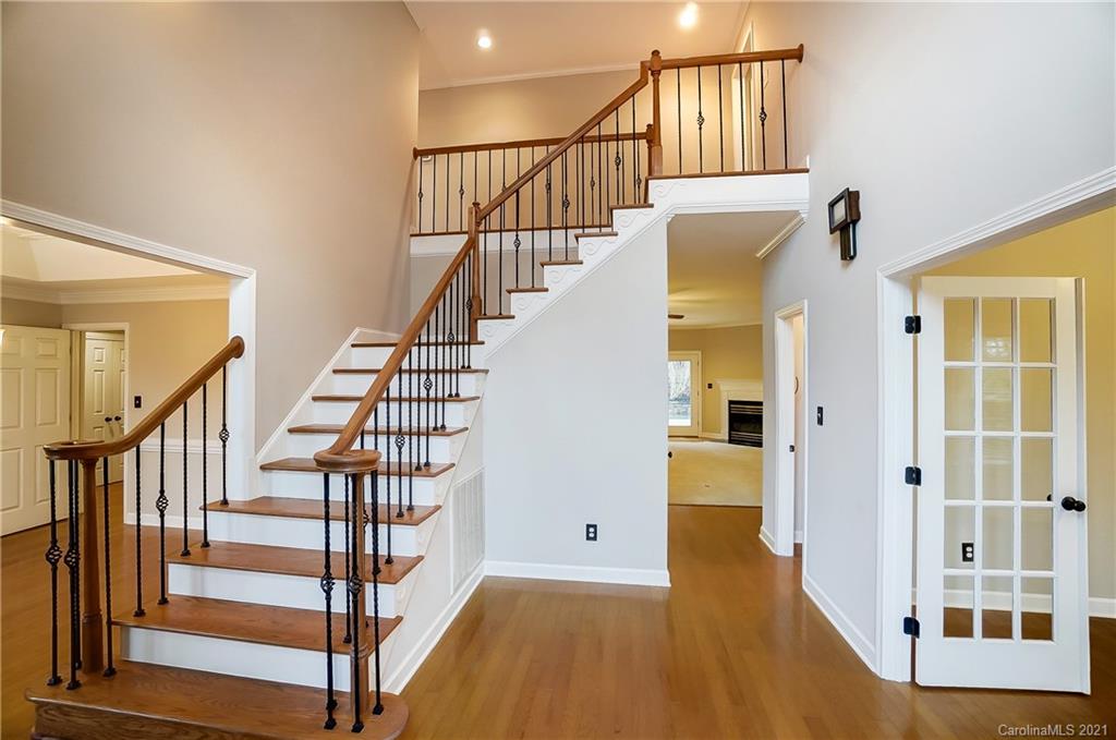 7064 Harbor Court Tega Cay, SC 29708 - Photo 5 of 48 a view of staircase with wooden floor and a chandelier
