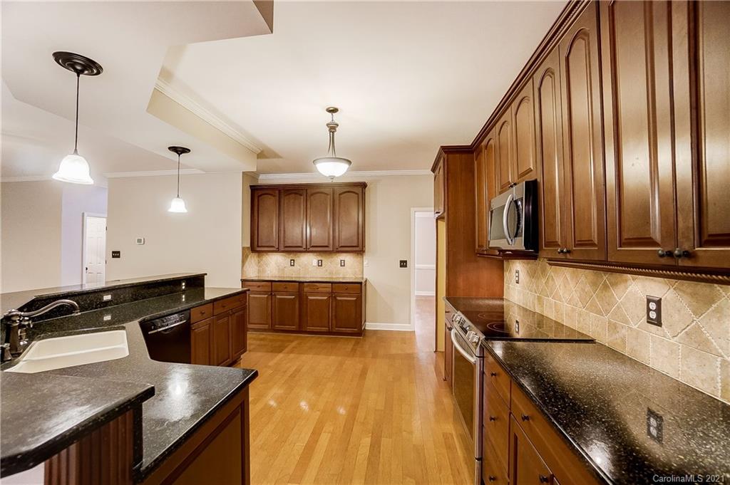 7064 Harbor Court Tega Cay, SC 29708 - Photo 10 of 48 a kitchen with granite countertop a stove a sink and a microwave