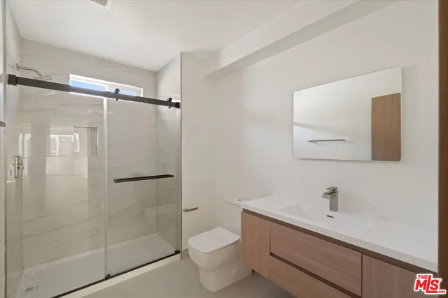 a bathroom with a shower toilet and sink