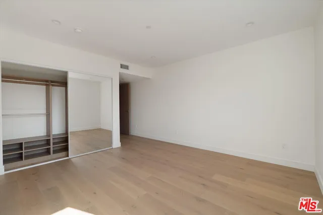 an empty room with wooden floor and sliding door