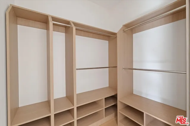 a view of walk in closet with empty racks