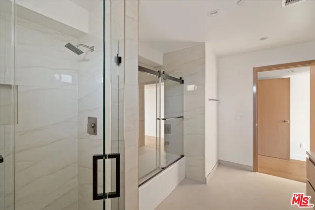 a bathroom with a shower and a glass door