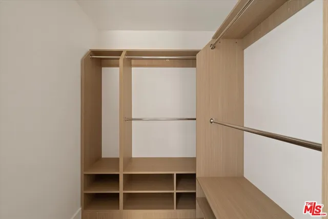 a view of walk in closet with empty racks