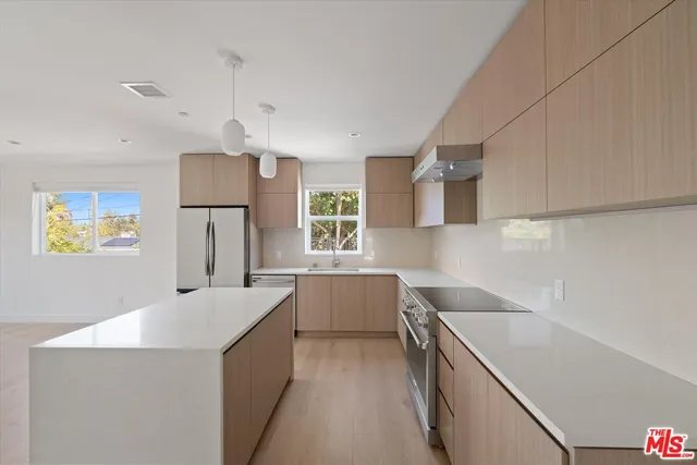 a kitchen with stainless steel appliances a sink a stove and a refrigerator