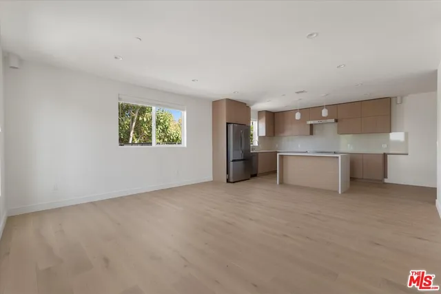 a view of a kitchen with a sink stove cabinets and empty room