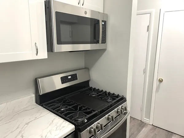 a stove top oven sitting inside of a kitchen
