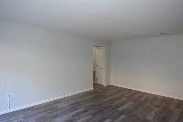 a view of an empty room and wooden floor