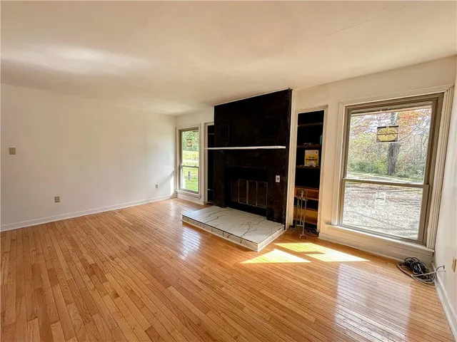 an empty room with wooden floor and fireplace