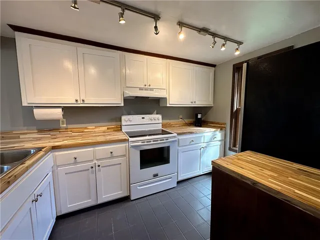 a kitchen with stainless steel appliances white cabinets and a refrigerator