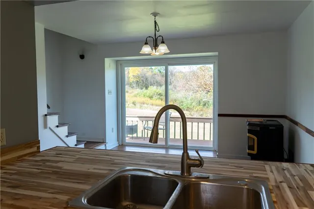a view of a livingroom with a fireplace a ceiling fan and wooden floor