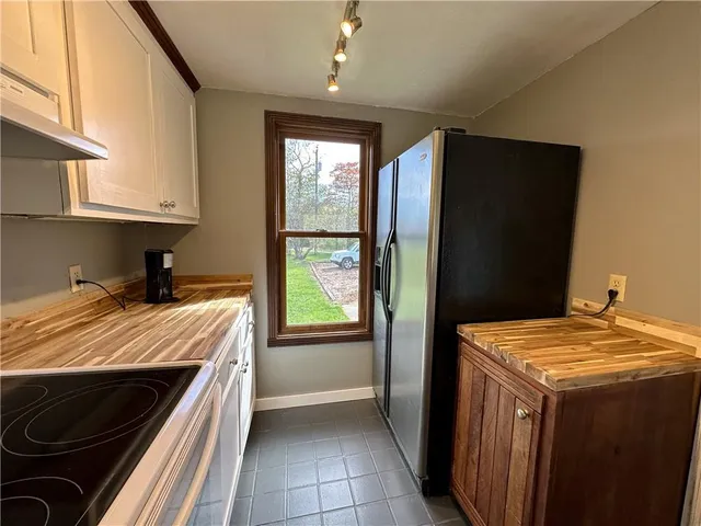 a bed sitting in a kitchen next to a window