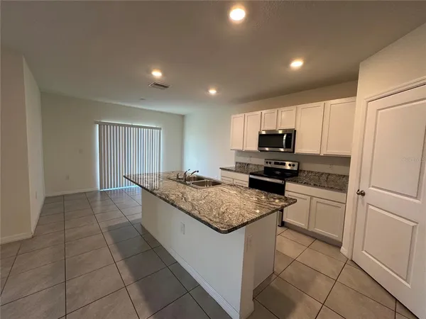 a kitchen with a stove a sink and a refrigerator