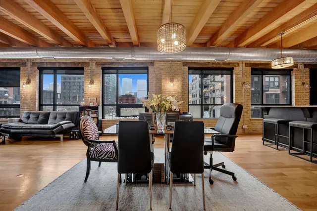 a view of a dining room with furniture a chandelier and wooden floor
