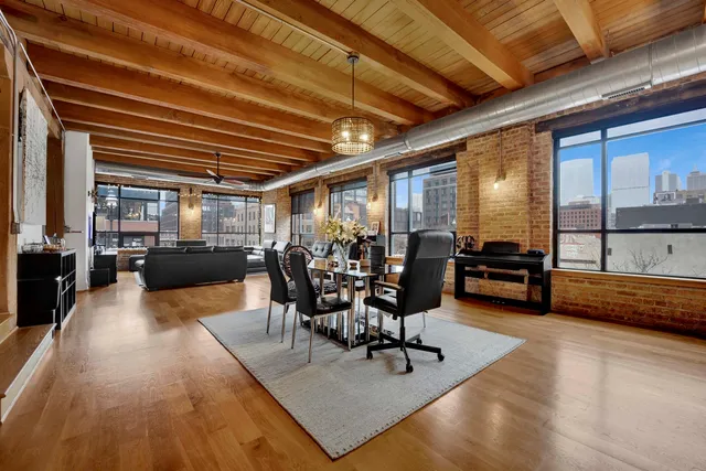 a living room with furniture ceiling fan and large windows