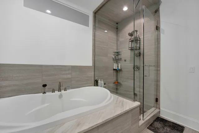 a bathroom with a double vanity sink mirror double and bathtub