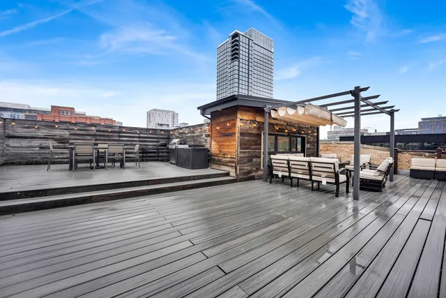 a view of a roof deck with couches and wooden floor