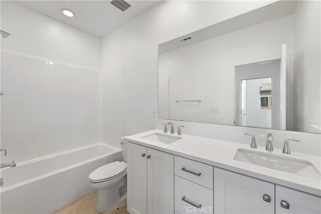 214 Denali Lake Forest, CA 92630 - Photo 7 of 11 a bathroom with a granite countertop sink a toilet and a bathtub