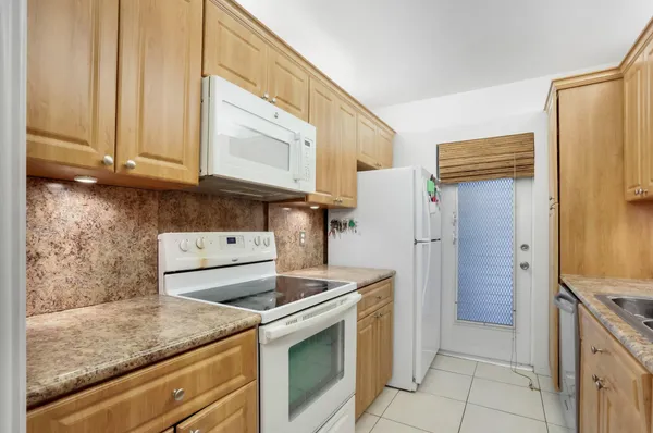 a kitchen with stainless steel appliances granite countertop a sink a stove and a refrigerator