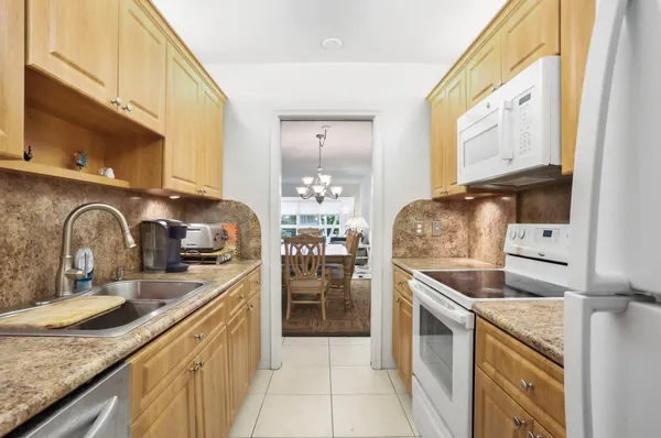 a kitchen with granite countertop a sink a stove and cabinets