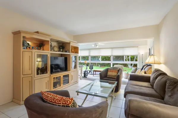 a living room with furniture a flat screen tv and a large window