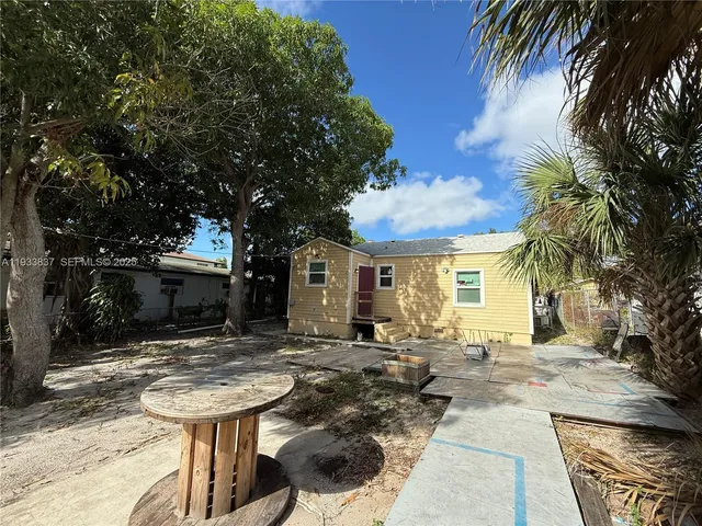 a view of a house with backyard and sitting area