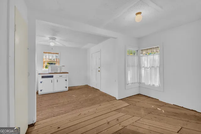 a view of a room with wooden floor and windows