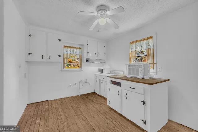 a kitchen with cabinets and wooden floor