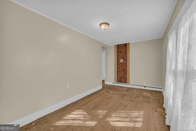 a view of an empty room with window and stairs