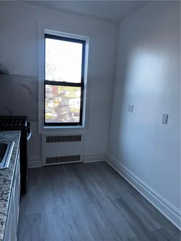 a kitchen with stainless steel appliances granite countertop a sink a stove and cabinets with wooden floor