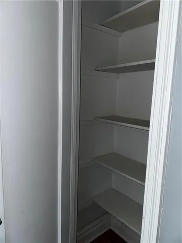 an empty room with wooden floor and entrance