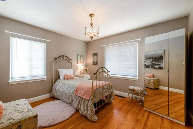 a bedroom with a bed wooden floor and window