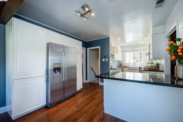 a kitchen with stainless steel appliances granite countertop a refrigerator a sink and a stove