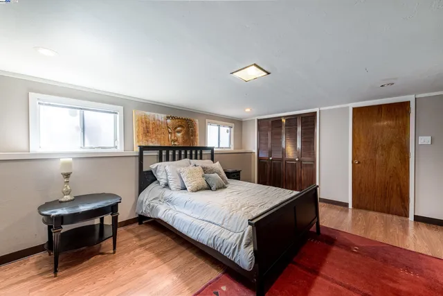 a large bedroom with a bed and wooden floor