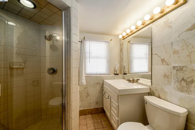 a bathroom with a sink toilet mirror and shower