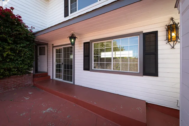 a front view of a house with a large window and potted plants