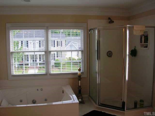 115 Rozelle Valley Lane Cary, NC 27519 - Photo 3 of 6 a bathroom with a bathtub and a shower