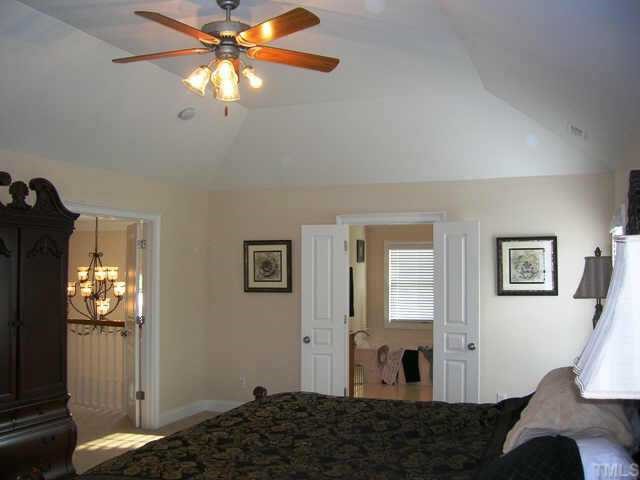 115 Rozelle Valley Lane Cary, NC 27519 - Photo 6 of 6 a bedroom with a bed and a chandelier